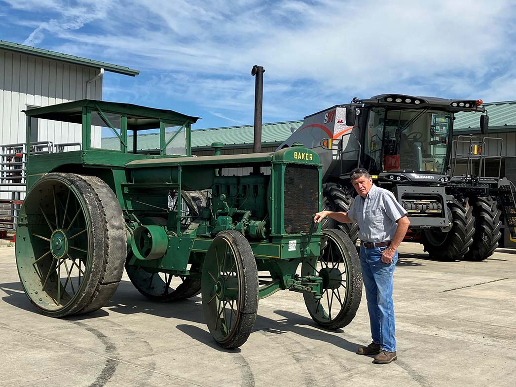 Old Baker Tractor with Man standing next to Tractor